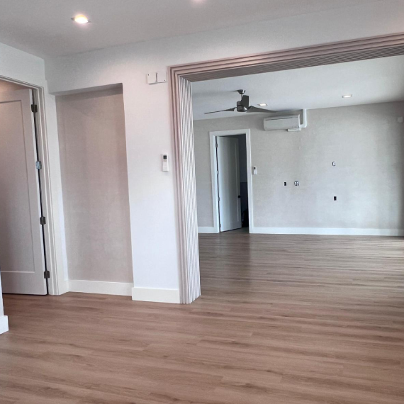 Interior view showing wood flooring and a decorative slatted archway leading to another room.